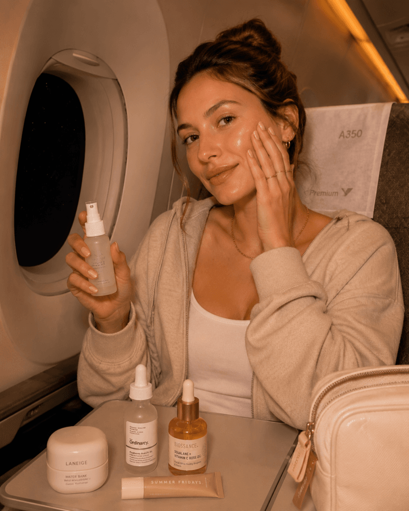  influencer applying ceramide moisturizer for dry skin on long haul flight
