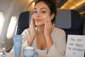 influencer applying ceramide moisturizer for dry skin on long haul flight