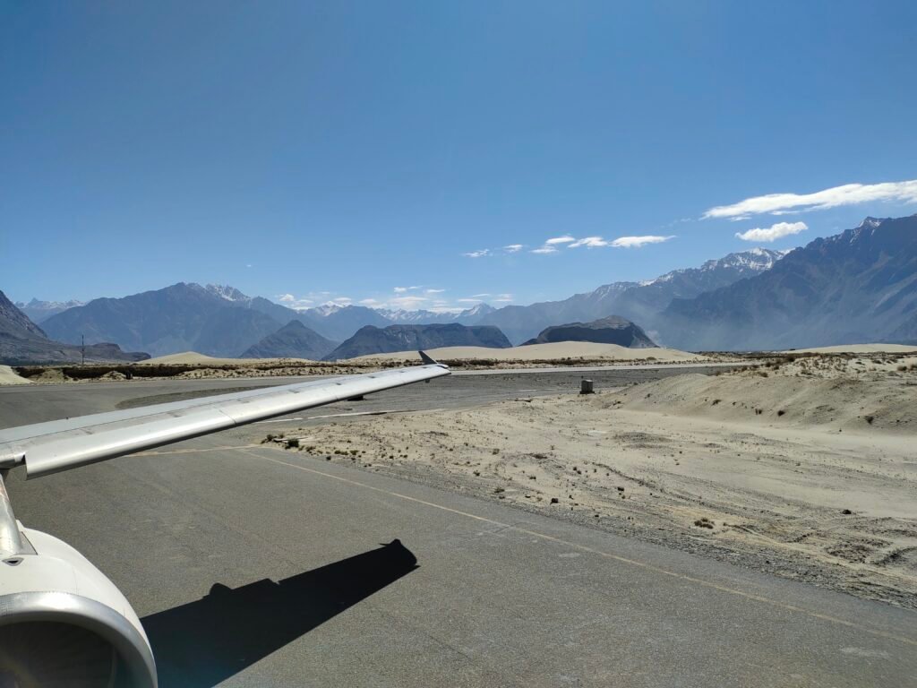 View from an aircraft window over the runway and surrounding valley at Skardu airport