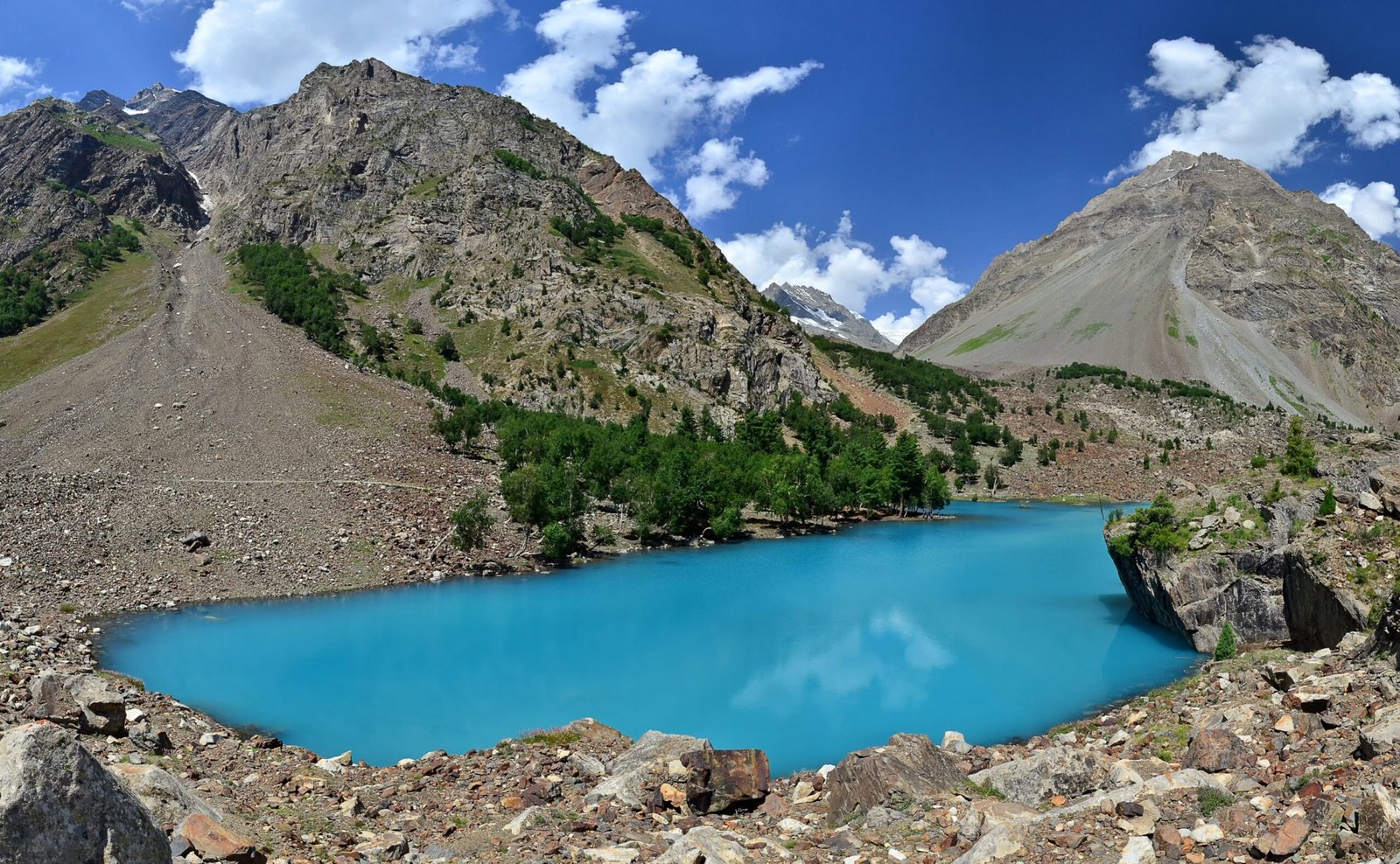 Turquoise water of Blue Lake beneath pine-fringed slopes in Naltar Valley.