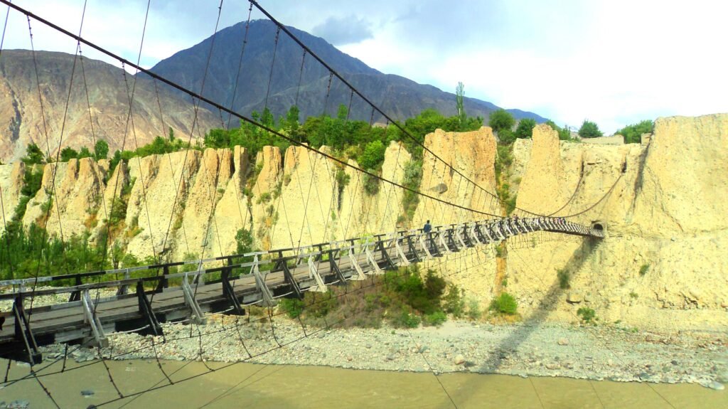 The Danyore Suspension Bridge crossing the river toward its tunnel opening in Gilgit