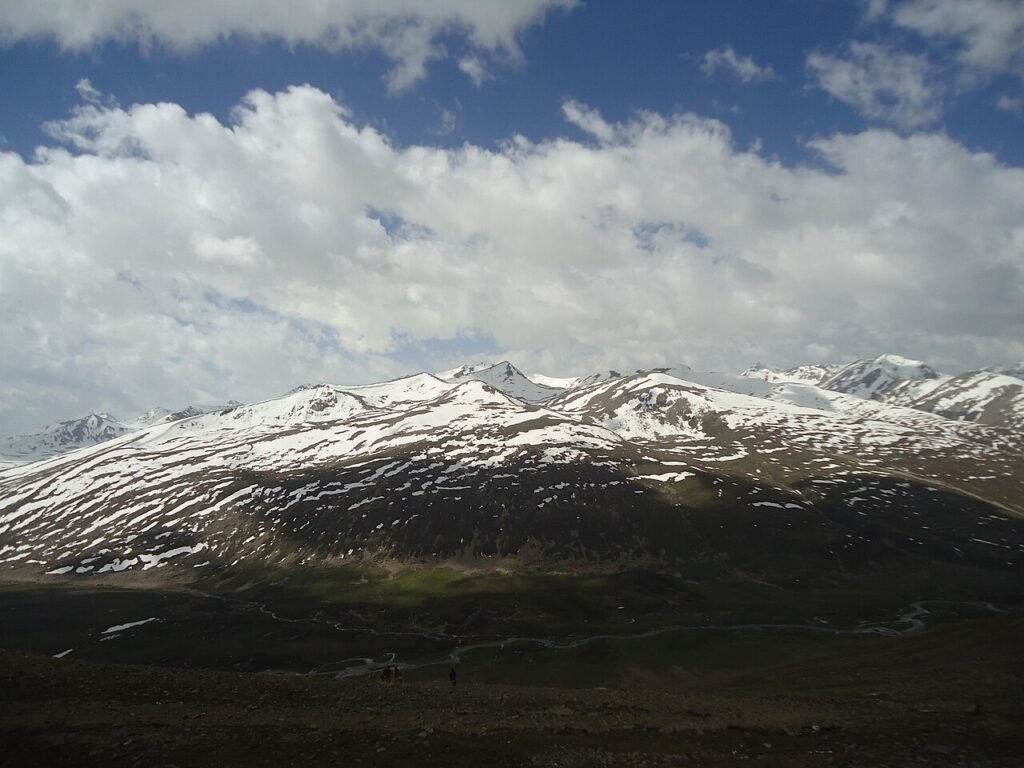 Snowy ridges above a green valley on the Deosai plateau