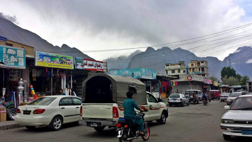 Shops and traffic in Gilgit's NLI market area beneath mountains