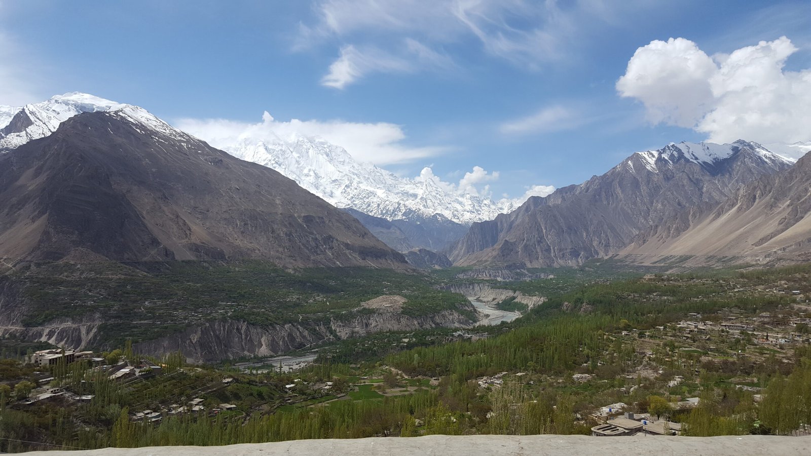 Terraced fields and village houses in the Hunza Valley, with snow-capped mountains behind