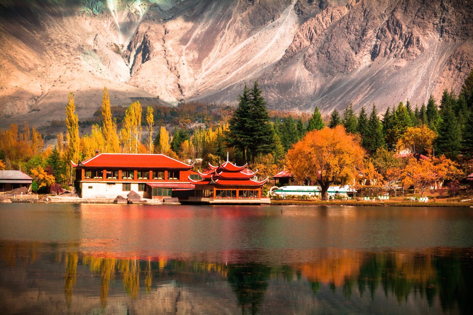 Shangrila Lake with the resort's red-roofed cottages reflected in the water, Skardu