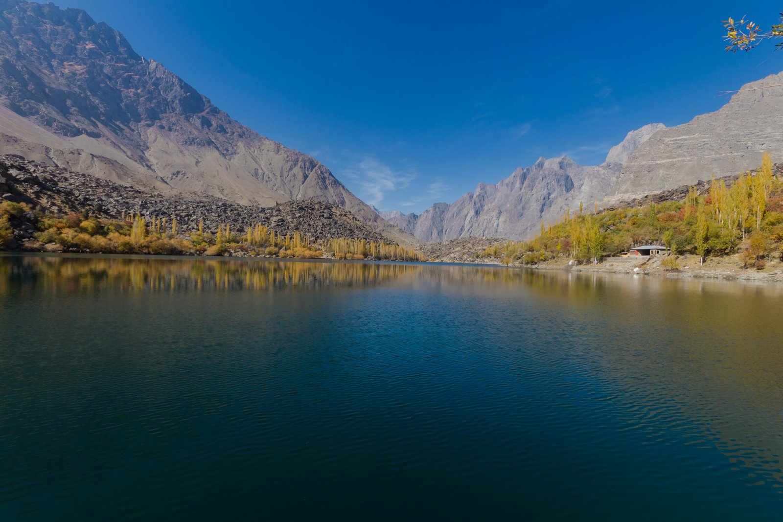 Upper Kachura Lake near Skardu, with autumn trees along the shore and mountains behind