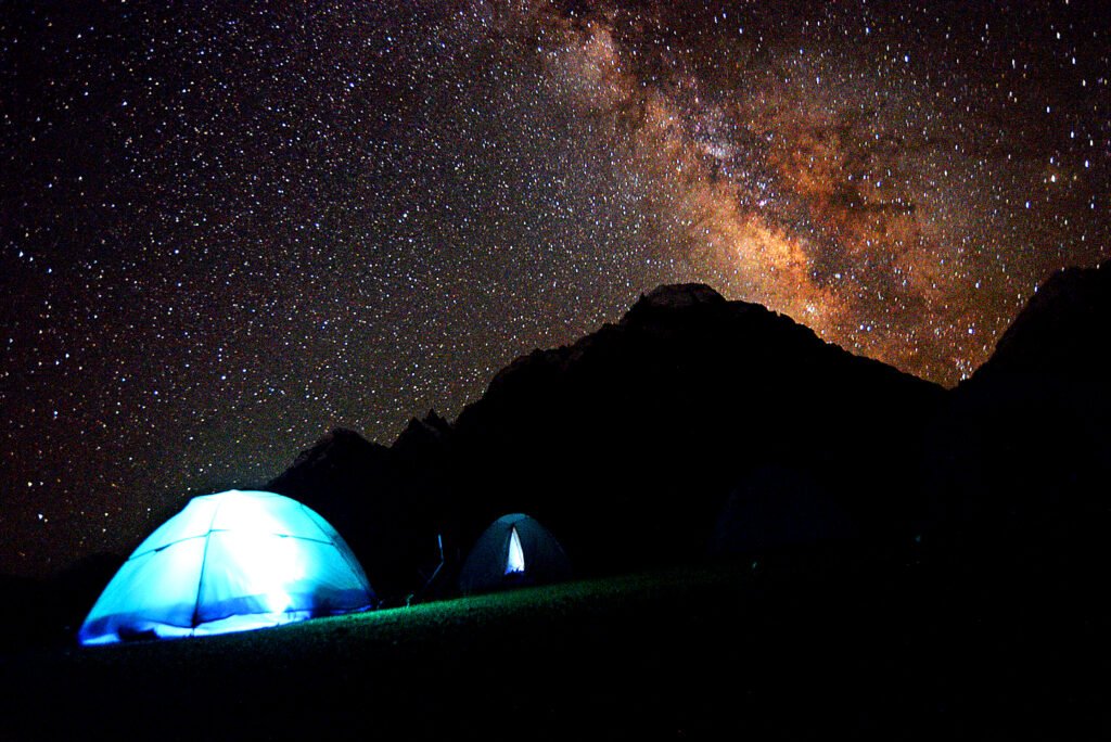 Tents lit at night under a starry sky in Hispar Valley
