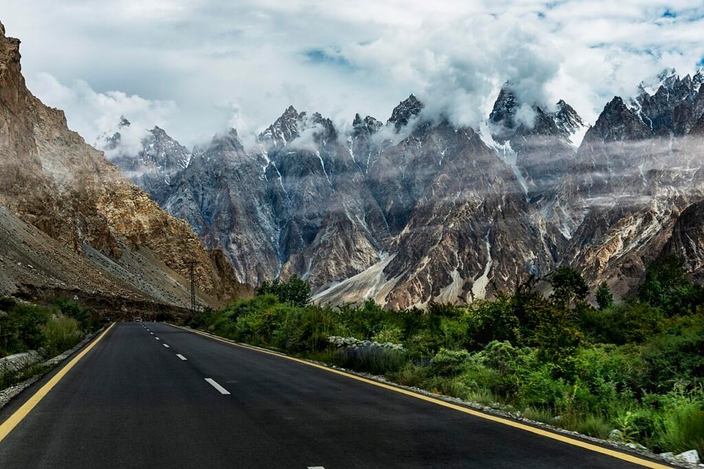 A vehicle on the Karakoram Highway below the Passu Cones in Upper Hunza, northern Pakistan, where travellers rely on SCOM coverage and offline maps.