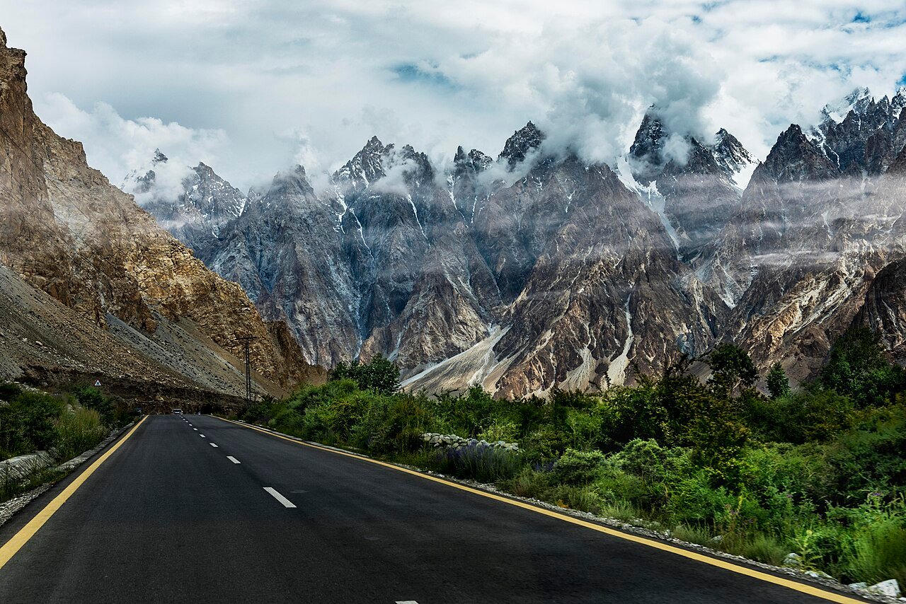A vehicle on the Karakoram Highway below the Passu Cones in Upper Hunza, northern Pakistan, where travellers rely on SCOM coverage and offline maps.
