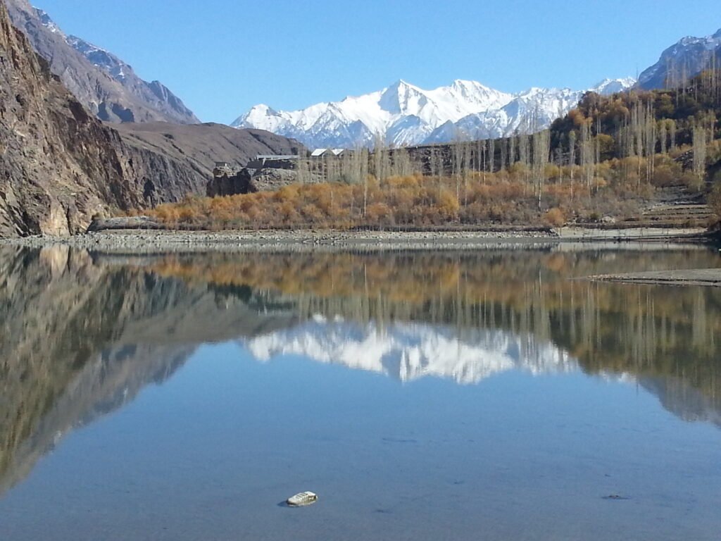 Khalti Lake with mirror reflections and snow-capped peaks near Gupis, Ghizer District