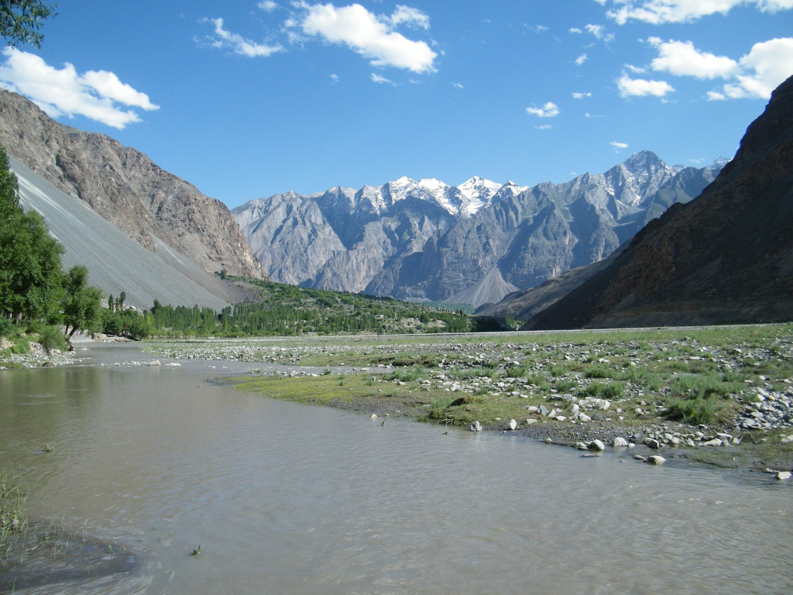 The Yasin River beside green fields in Yasin Valley, Ghizer District